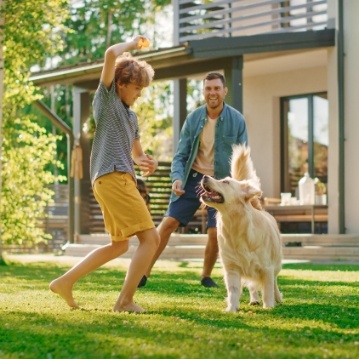 family playing catch with dog